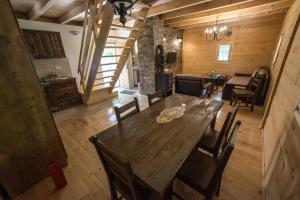 a dining room with a wooden table and chairs at Gradačka Banja brvnare in Gradac