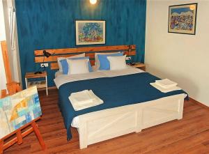 a bedroom with a large bed with blue walls at MaraMare Apartments in Stara Baška
