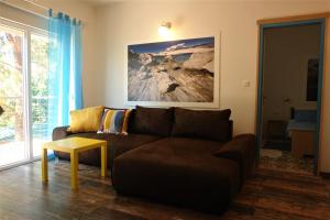 a living room with a brown couch and a table at Quercus Apartment in Stara Baška