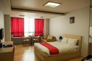a bedroom with a bed and a desk and a window at Hotel Hu Incheon Airport in Incheon +35 photos