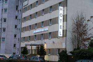 ein Gebäude mit einem Schild auf der Seite des Hotels in der Unterkunft Hotel Niederräder Hof in Frankfurt am Main