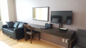 a living room filled with furniture and a tv at Hotel Hu Incheon Airport in Incheon