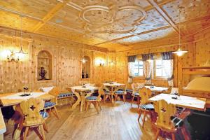restauracja z drewnianymi ścianami, stołami i krzesłami w obiekcie Landhotel Alpenhof Filzmoos w mieście Filzmoos