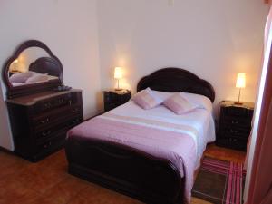 a bedroom with a bed with two dressers and a mirror at Casa da Sogra in Faja Grande