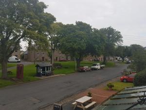 a view of a street with cars parked on the road at Plough Hotel in Kirk Yetholm