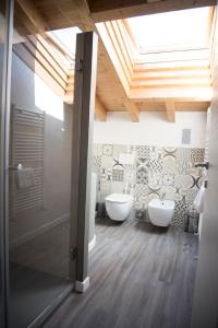 ロナートにあるMichela BB & Relaisのバスルーム(白いトイレ2つ、天窓付)