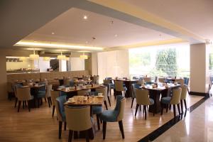 a restaurant with tables and chairs and a large window at St Mark Hotel in Cebu City