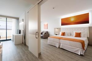 a bedroom with a large bed and a living room at Sandos Papagayo in Playa Blanca