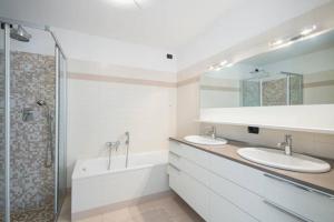 a white bathroom with two sinks and a shower at Parco San Andrea Elegante in Menaggio