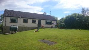 a yard with a house and a playground at Lakeview House in Ballinamore