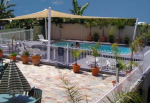 una piscina con una valla blanca y plantas en Waterview Luxury Apartments, en Merimbula