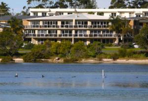 a large building on the shore of a lake at Waterview Luxury Apartments in Merimbula