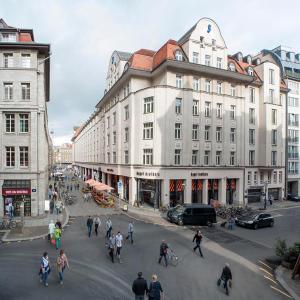 un gruppo di persone che attraversa una strada di fronte agli edifici di Apartments Zentrum Brühl a Lipsia