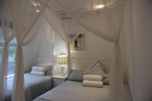 a bedroom with two beds and a window at Campismo Ninho 40 in Ponta Malangane