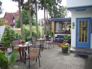 eine Terrasse mit Tischen und Stühlen und einer blauen Tür in der Unterkunft Aparthotel Klara in Timmendorfer Strand