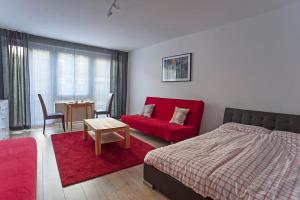 ライプツィヒにあるApartments Zentrum Brühlのベッドルーム(赤いベッド1台、赤いソファ付)