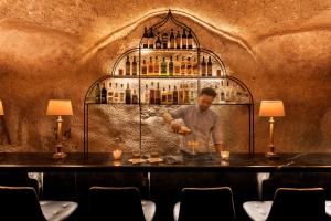 a man standing at a bar making a drink at Villa Brown Jerusalem, a member of Brown Hotels in Jerusalem