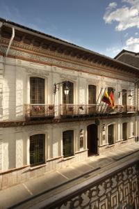 a white building with a flag on a balcony at Mansion Alcazar in Cuenca