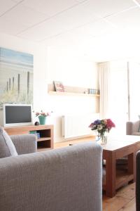 Apartment Boven Jan 574 في دن هيلدر: غرفة معيشة مع أريكة وطاولة
