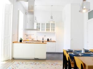 a kitchen with white cabinets and a table with chairs at City Hall Correos in Valencia