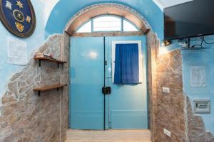 ローマにあるIn the heart of Trastevereの石壁の部屋の青いドア