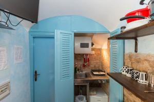 ローマにあるIn the heart of Trastevereの青いドアとシンク付きの小さなキッチン