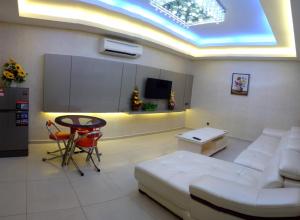 a living room with a white couch and a table at Golden Leaves Hotel in Melaka