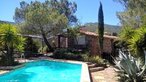 a pool in front of a house with trees at Mas Montebello in Rigarda