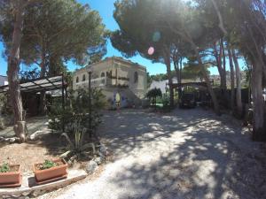 ein großes weißes Haus mit Bäumen davor in der Unterkunft Villa Genna in San Vito lo Capo