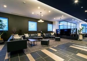 a lobby with couches and tables and a tv at Daiwa Roynet Hotel Koriyama Ekimae in Koriyama