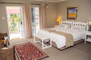 sypialnia z 2 łóżkami i balkonem w obiekcie Diaz Beach Guest House w mieście Mossel Bay