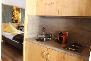 a small kitchen with a sink and a bed at Haus Hintertux in Tux