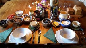a wooden table topped with plates and bowls of food at Buckthorns House in Leven-Fife