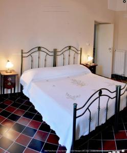 a bedroom with a large white bed with two tables at b&b porta nuova mesagne in Mesagne