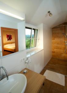 a bathroom with a sink and a shower and a mirror at Toso Genussreich in Leutschach +44 photos