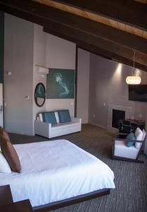 - une chambre avec un grand lit et une cheminée dans l'établissement Munras Inn, à Monterey