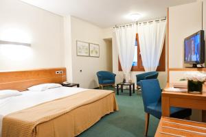 una stanza d'albergo con un letto e due sedie di Ca' delle Rose a Castelfranco Veneto Altre 41 foto