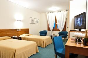 a hotel room with two beds and a flat screen tv at Ca' delle Rose in Castelfranco Veneto