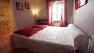 Un dormitorio con una cama con almohadas rojas. en La Prade des "Pierre", en Mazamet