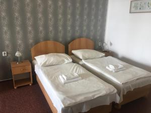 two beds in a hotel room with white sheets at Hotel City in Pardubice