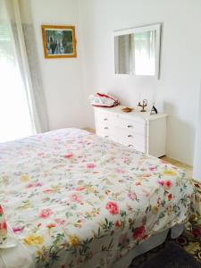 a bedroom with a bed with a floral bedspread at Casona Villa Paquita - Lujosa Villa de 1913 in Ondara