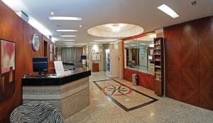 a lobby with a reception desk in a building at Lira Hotel in Curitiba