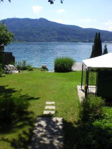 a large yard with a view of a lake at Haus Angelika - Ferienwohnung Wörthersee in Pörtschach am Wörthersee