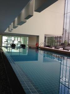 a swimming pool with blue tiles in a building at The Grand Wipanan Residence in Chiang Mai