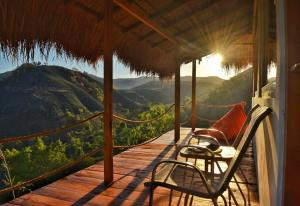 a porch with two chairs and a view of a mountain at Morinda Villa and Resto in Waingapu