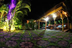 a patio at night with lights at Villa Gede Private Guest House in Selemadeg