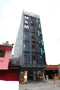 Un palazzo alto e nero con un cartello sopra. di M&M Hotel a Kuala Lumpur