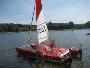 two people on a small sail boat in the water at Ferienwohnung Wölfel in Schwarzenbach an der Saale