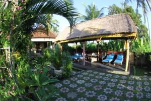 a resort with a thatched pavilion with a garden at Villa Gede Private Guest House in Selemadeg