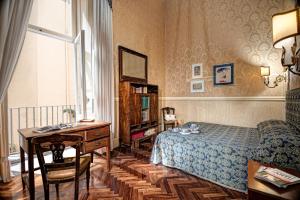 a bedroom with a bed and a desk and a desk sidx sidx sidx at Arthouse Lady Marys Tribunali Luxury Suite in Naples